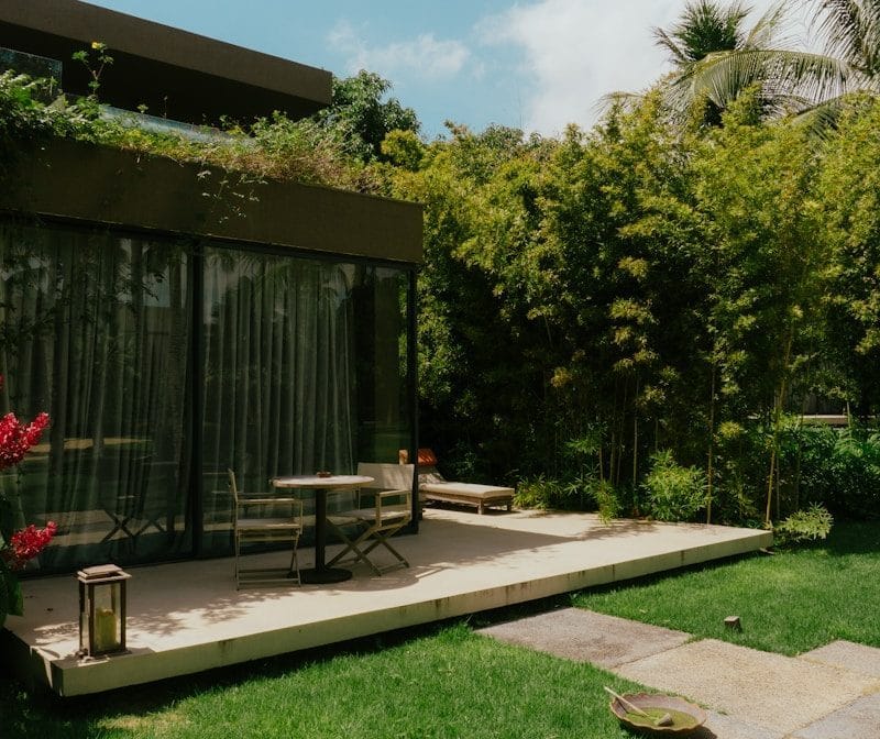 a patio with a table and chairs in the grass